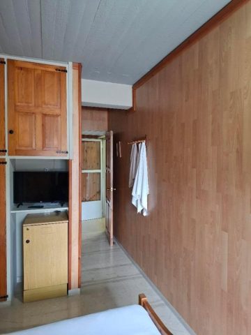 Room 1 Εσωτερική άποψη του Δωματίου 1 στο EVDOXIA Hotel, με ξύλινες επενδύσεις, ντουλάπα, τηλεόραση, ψυγείο και μέρος του διπλού κρεβατιού.